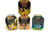 trois boîtes sur lesquelles figurent différents types de Pokémon, posées sur une surface blanche