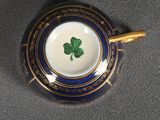 a close up of a blue and gold cup with a shamrock on it