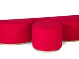 trois tabourets rouges placés les uns à côté des autres sur une surface blanche