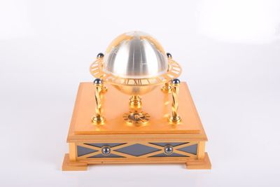 une horloge en or et en argent posée sur un socle en bois