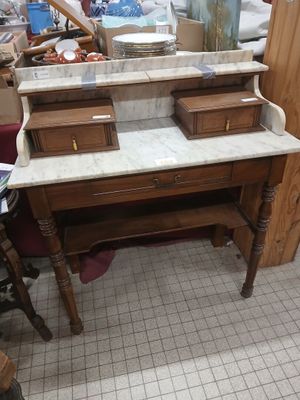 a marble top desk with two drawers and a mirror