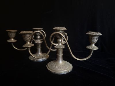 trois bougeoirs en argent sur fond noir