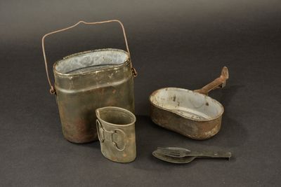 a metal bucket and a metal spoon next to it