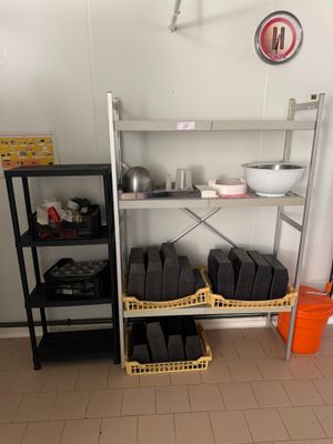 une pièce avec une étagère et des rayons remplis de casseroles, de poêles et de plats