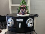 une machine à café sur laquelle est posé un sapin de Noël