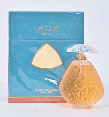 l'image d'un flacon de parfum posé à côté d'une boîte