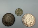 three silver and one silver coins sitting on top of a table