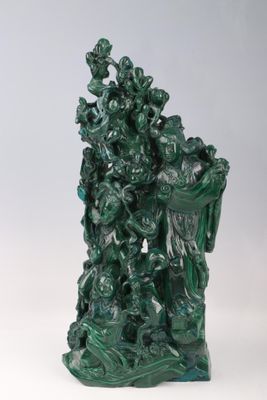 statue représentant un groupe de personnes sur un socle vert, avec un fond blanc