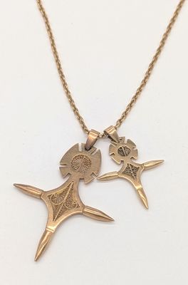 un gros plan d'un collier orné de deux oiseaux