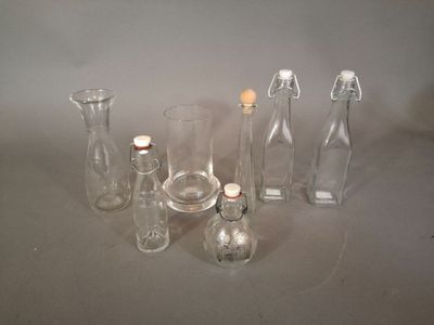 de nombreuses bouteilles et vases en verre posés sur une table
