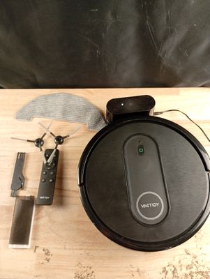 a black robot sitting on top of a wooden table