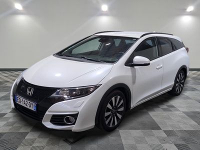 La Honda Civic blanche est garée sur un sol carrelé à damier.
