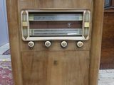 une radio à l'ancienne posée par terre dans une pièce