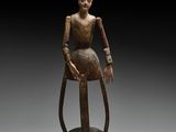 une statue en bronze représentant une femme assise sur un rocher