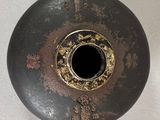 a black vase with a hole in it on a table