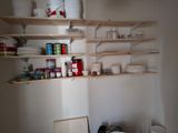 a small kitchen with a lot of shelves and dishes on the shelves