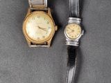 two watches that are sitting next to each other on a table