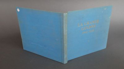 un vieux livre bleu posé sur une table près d'un mur gris