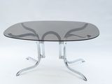 une table ronde en verre avec des pieds chromés et un plateau en verre