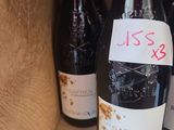 several bottles of wine in a wooden box with a price tag