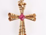 an image of a gold cross with a pink stone in the center