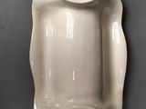 a white vase with a lid on a gray surface