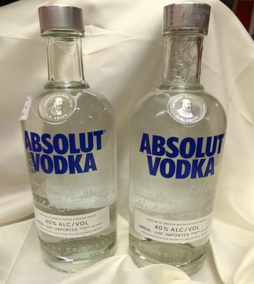 deux bouteilles de vodka Absolut posées sur une nappe blanche
