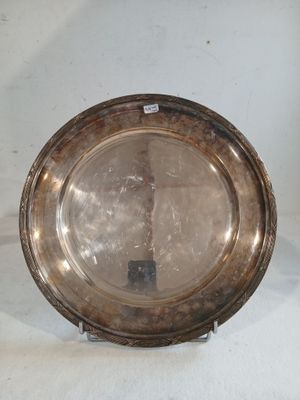 une assiette en argent posée sur une surface blanche