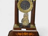 a clock that is sitting on a stand on a white surface