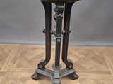 an antique black marble top table on a wooden floor