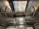a stainless steel shelf with a glass window above it