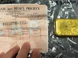 quelqu'un tient un morceau d'or à côté d'un lingot d'or