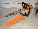 an orange chainsaw sitting on top of a table next to a plastic tool