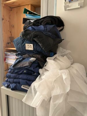a stack of folded clothes on a shelf in a room