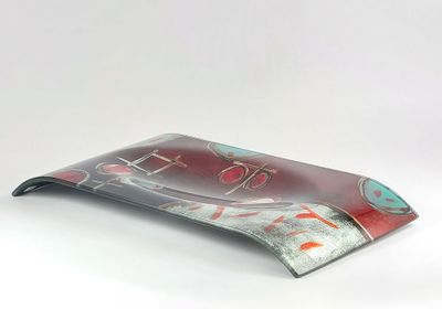 un plateau en verre orné d'un motif rouge et bleu