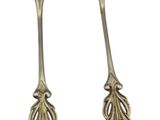 pair of silver spoons with leaves on them on a white background