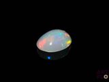 a white oplite in the dark with a black background