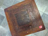 an old book sitting on top of a rug on a tiled floor