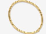 gros plan d'un bracelet en or sur fond blanc