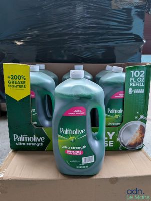 three bottles of palmolive sit in a cardboard box on the street