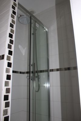 a walk in shower with a glass door in a bathroom