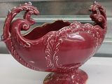 a red vase with a dragon on it on a table