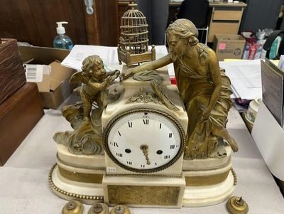 une statue de femme tenant une horloge sur une table