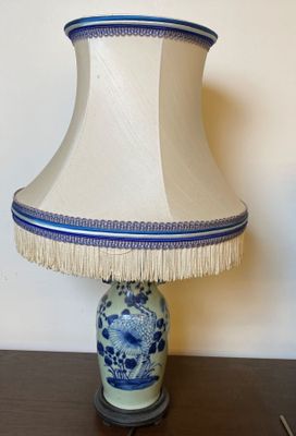 une lampe de table bleue et blanche, surmontée d'un abat-jour blanc