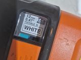 a close up of an orange and black corded nail grinder