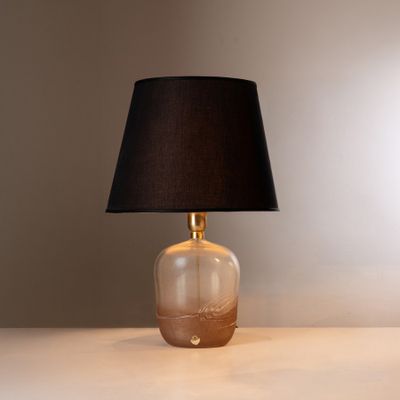 une lampe posée sur une table avec un abat-jour noir