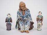 three figurines of a woman sitting on a bench with a dog
