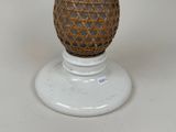 a white vase with a wicker ball on top of it