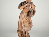 statue en bois représentant une femme tenant un panier de fleurs