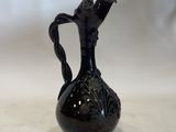 a black vase that is sitting on a table